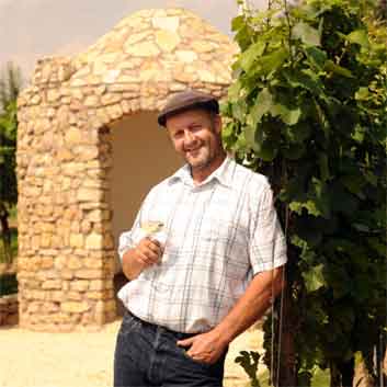 Hubert Schreiber posiert mit Weinglas vor dem Trullo in Gundheim für die Weinprobe